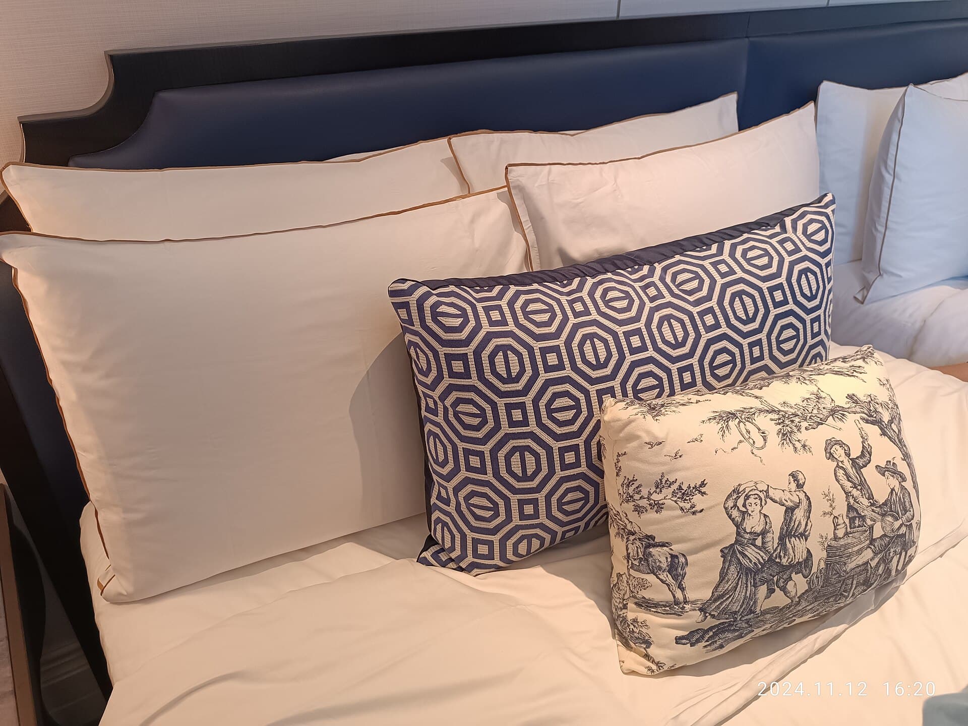 Foto ilustrativa de travesseiros brancos e almofadas em uma cama